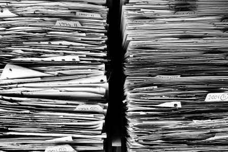 Two large piles of documents in black and white.