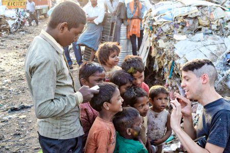 Aid worker with several chuldren in a refugee camp.